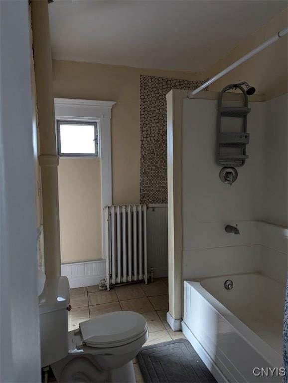 full bathroom featuring radiator heating unit, tile patterned flooring, toilet, and shower / bath combination