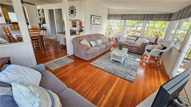 living room featuring lofted ceiling, hardwood / wood-style flooring, and ceiling fan