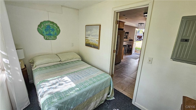 bedroom featuring hardwood / wood-style floors, electric panel, and stainless steel refrigerator