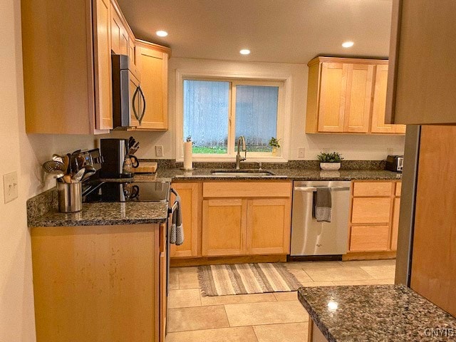 kitchen with light brown cabinetry, sink, appliances with stainless steel finishes, and dark stone countertops