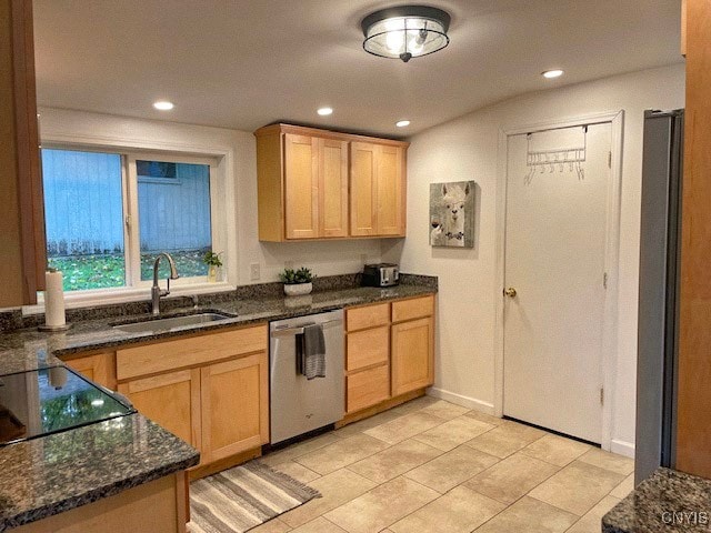 kitchen featuring light brown cabinetry, sink, stainless steel dishwasher, dark stone countertops, and light tile patterned floors