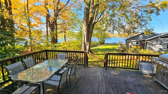 wooden terrace with a water view and a yard