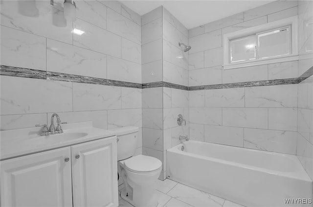 full bathroom with toilet, tile walls, vanity, and tiled shower / bath combo