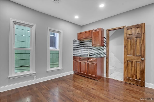 kitchen with light wood-type flooring and tasteful backsplash