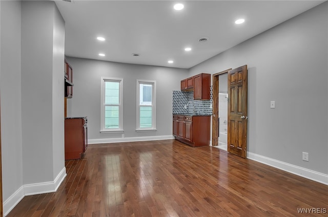 kitchen with dark wood-type flooring and backsplash