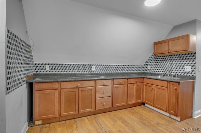 767 W Ave, Buffalo, NY 14213 - kitchen featuring a sink, vaulted ceiling, light wood-style floors, dark countertops, and decorative backsplash
