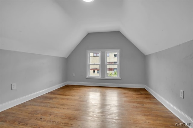 bonus room with vaulted ceiling and light wood-type flooring