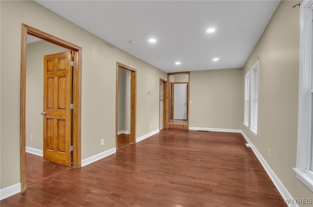 unfurnished room with dark wood-type flooring