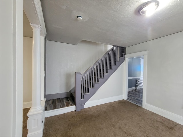 stairway with carpet and a textured ceiling