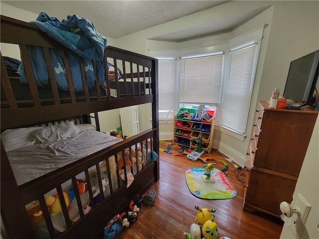 bedroom featuring hardwood / wood-style floors and a textured ceiling