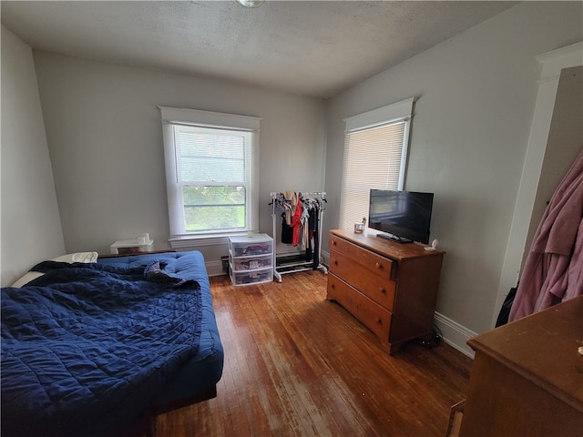 bedroom featuring a textured ceiling and dark hardwood / wood-style floors