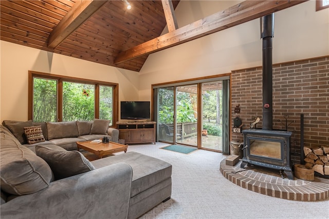 carpeted living room with a wood stove, plenty of natural light, vaulted ceiling with beams, and wood ceiling