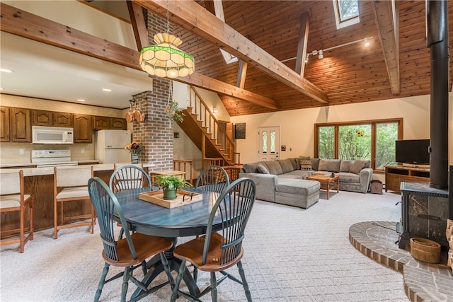 dining area with wooden ceiling, light carpet, and lofted ceiling with skylight