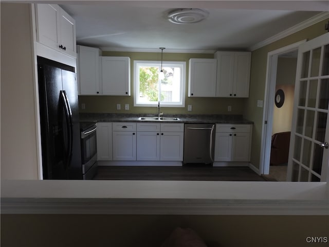 kitchen with sink, appliances with stainless steel finishes, pendant lighting, and white cabinets