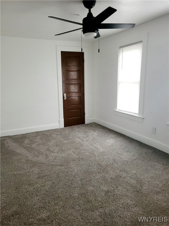 empty room with ceiling fan and carpet flooring