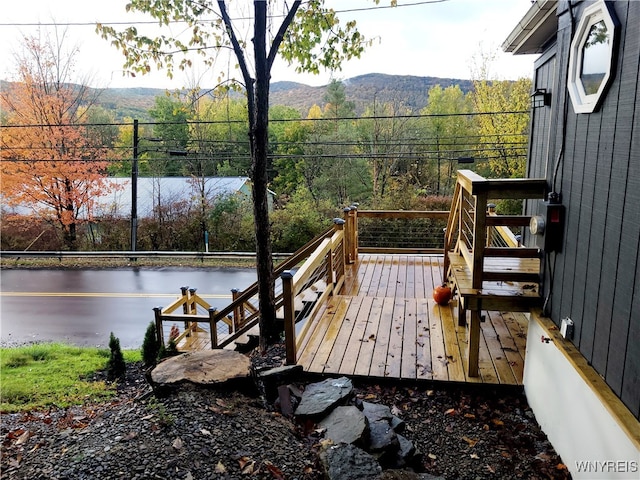 wooden deck featuring a water and mountain view