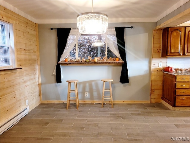 interior space with baseboard heating, light hardwood / wood-style flooring, an inviting chandelier, and wood walls