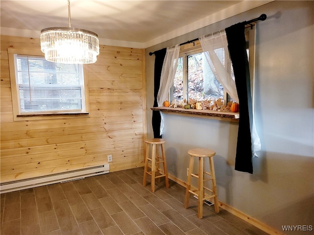 unfurnished dining area with a baseboard radiator, wooden walls, wood-type flooring, and an inviting chandelier