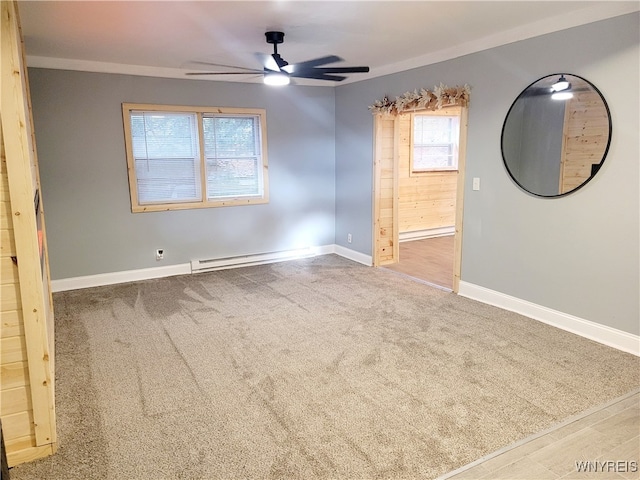 unfurnished room with ceiling fan, wood-type flooring, a baseboard radiator, and wooden walls