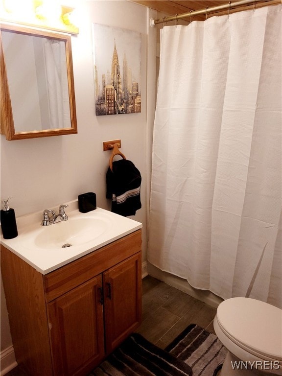 bathroom featuring vanity, hardwood / wood-style floors, a shower with shower curtain, and toilet