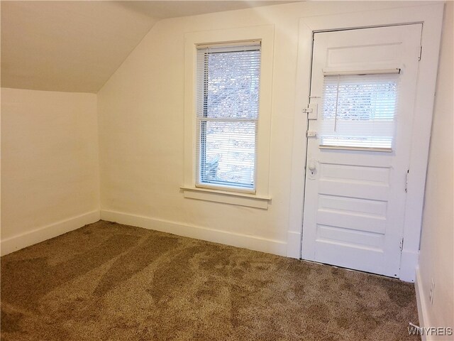 interior space featuring carpet floors and vaulted ceiling