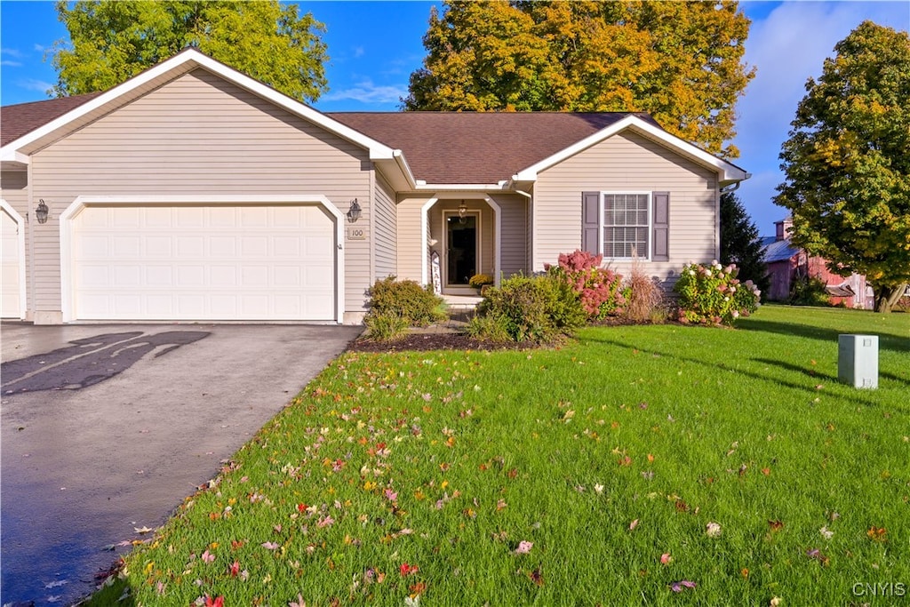 ranch-style house featuring a front yard and a garage