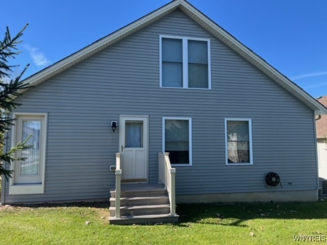 rear view of property with a yard