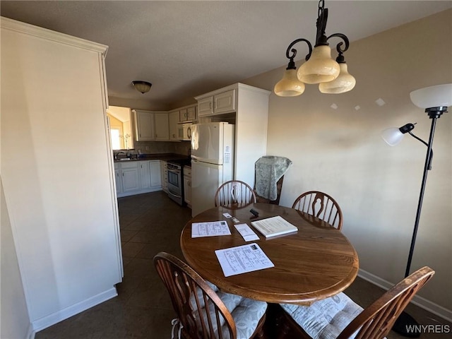 dining area featuring dark tile patterned floors and baseboards