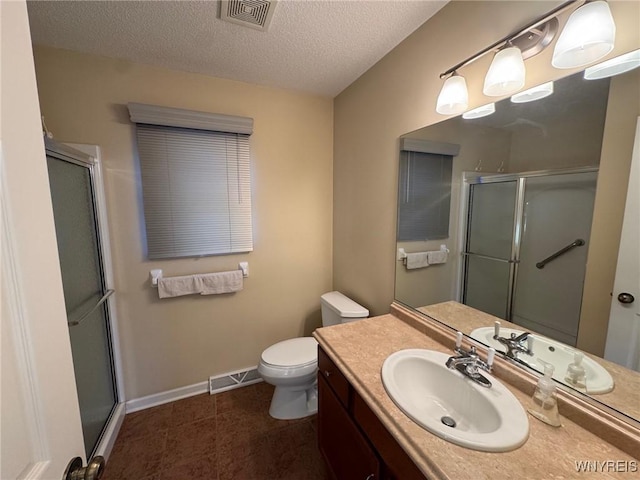 full bath featuring visible vents, toilet, a shower stall, a textured ceiling, and vanity