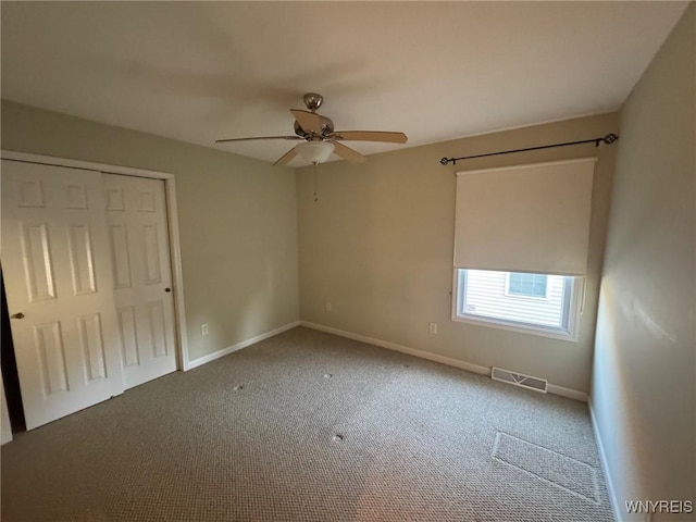 unfurnished bedroom featuring baseboards, visible vents, a ceiling fan, carpet, and a closet