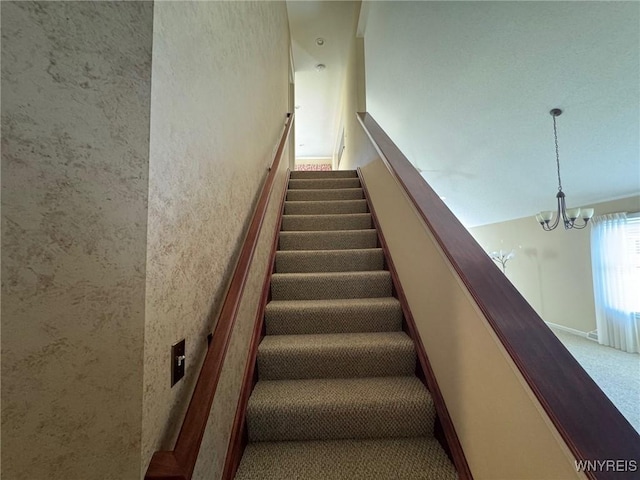 stairway featuring a chandelier and carpet flooring