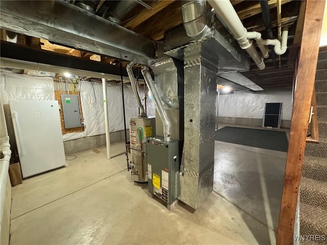 unfinished below grade area with freestanding refrigerator, gas water heater, electric panel, and stairway