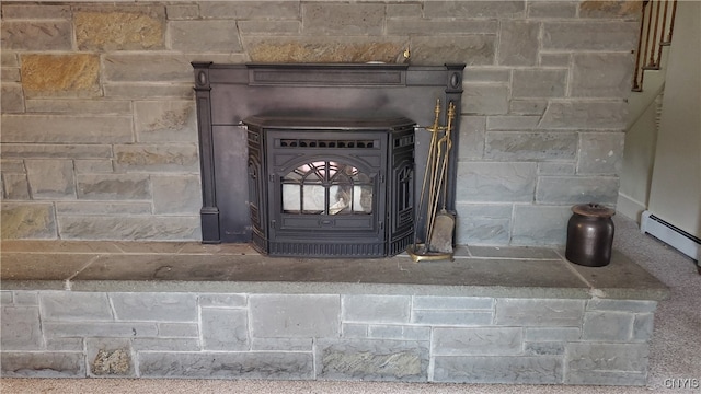 details with a wood stove and a baseboard heating unit