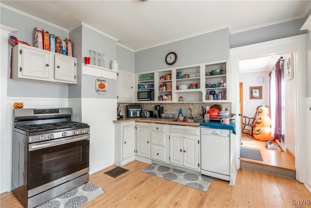 kitchen with sink, appliances with stainless steel finishes, white cabinetry, and light wood-type flooring