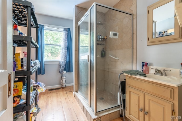 bathroom featuring a shower with door, hardwood / wood-style floors, and vanity