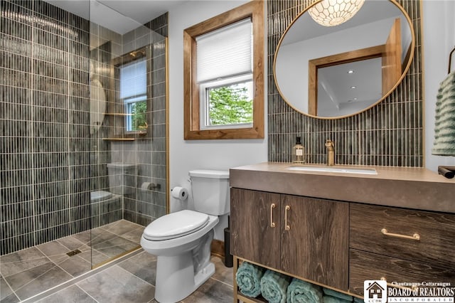 bathroom featuring decorative backsplash, tile walls, toilet, tiled shower, and vanity