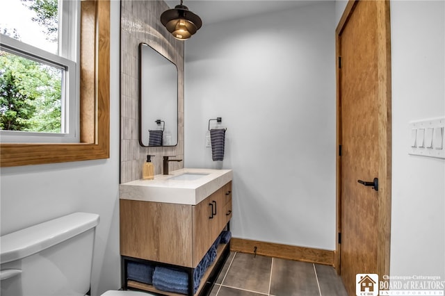 bathroom featuring toilet, vanity, and tile patterned flooring