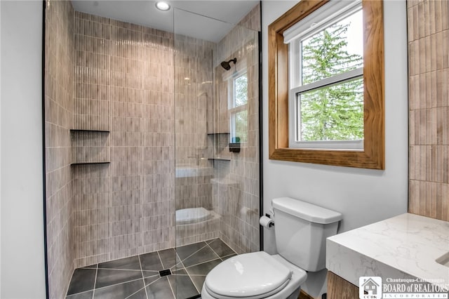 bathroom featuring toilet and a tile shower