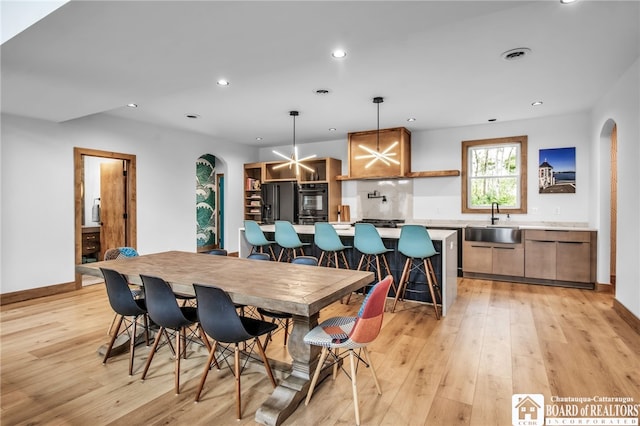 dining room with sink and light wood-type flooring