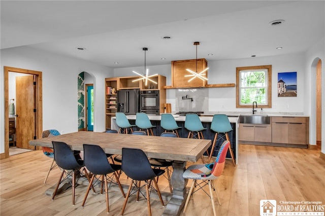 dining space with sink and light wood-type flooring