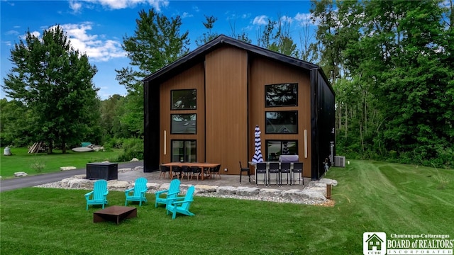 rear view of house featuring a patio and a lawn