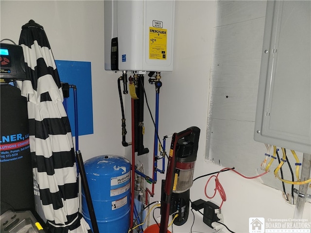 utility room with electric panel and tankless water heater