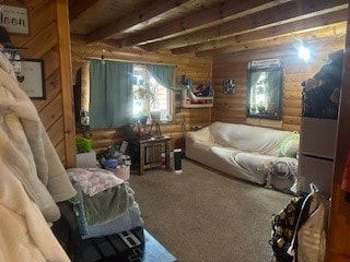 interior space with carpet flooring, wood walls, and beamed ceiling