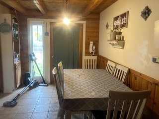 dining space featuring wooden walls and wooden ceiling