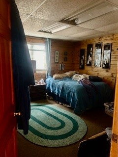 bedroom featuring wood walls