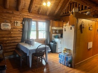 dining space with log walls, lofted ceiling with beams, wood-type flooring, and wooden ceiling