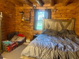 bedroom with beam ceiling and log walls