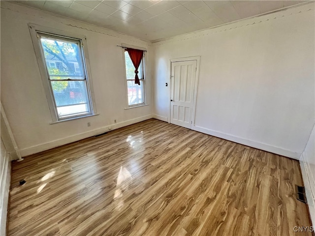 spare room featuring light hardwood / wood-style floors and crown molding