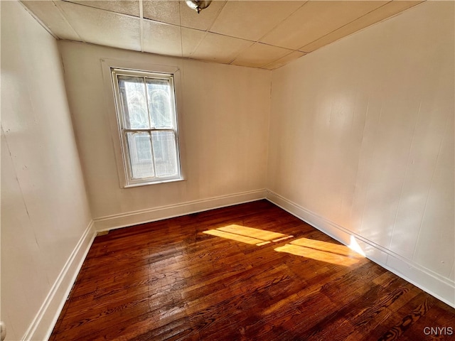 empty room featuring wood-type flooring and a paneled ceiling