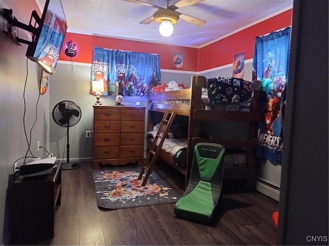 bedroom with ornamental molding, baseboard heating, wood finished floors, and a ceiling fan